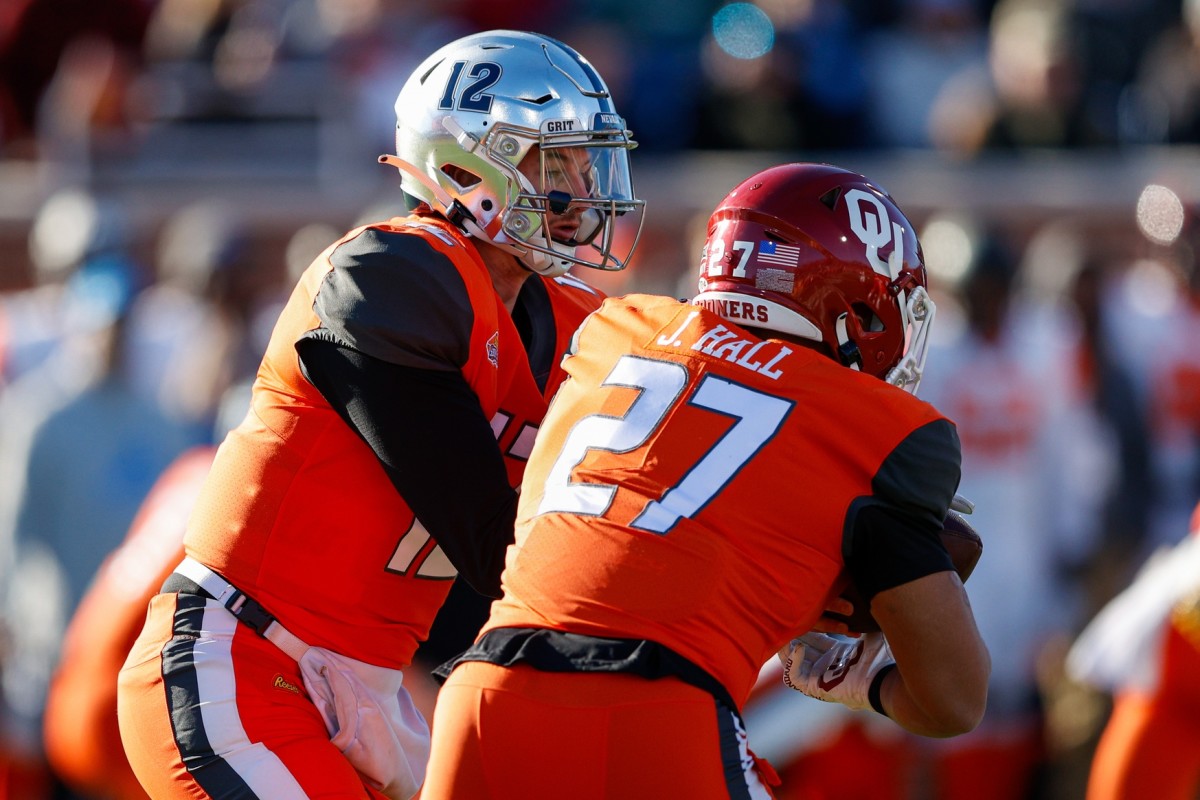 Feb 5, 2022; Mobile, AL, USA; National Squad quarterback Carson Strong of Nevada (12) hands off to fullback Jeremiah Hall of Oklahoma (27) in the second half against the American squad during the Senior bowl at Hancock Whitney Stadium.