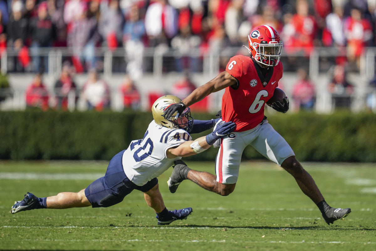 Nov 20, 2021; Athens, Georgia, USA; Georgia Bulldogs running back Kenny McIntosh (6) breaks a tackle by Charleston Southern Buccaneers linebacker Garrett Sayegh (40) on his way to scoring a touchdown during the first quarter at Sanford Stadium. Mandatory Credit: Dale Zanine-USA TODAY Sports