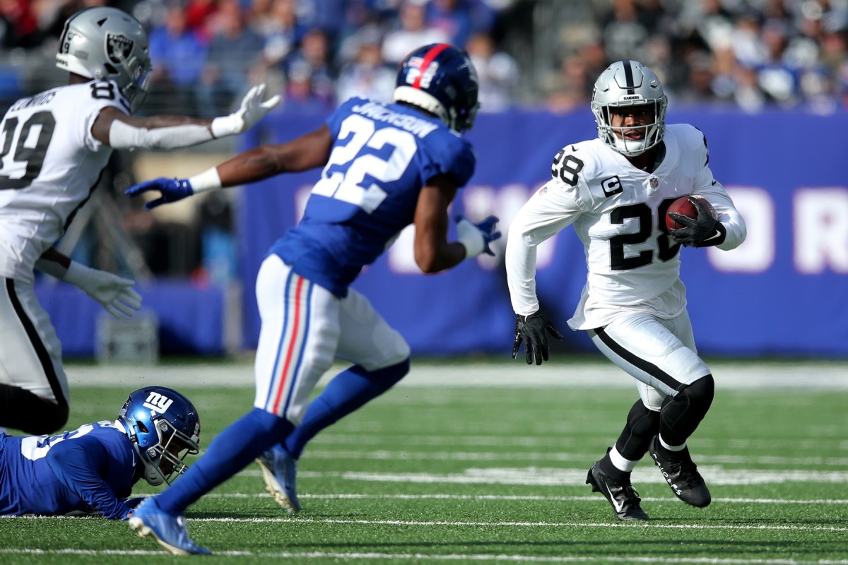 Nov 7, 2021; East Rutherford, New Jersey, USA; Las Vegas Raiders running back Josh Jacobs (28) runs the ball against New York Giants cornerback Adoree' Jackson (22) during the first quarter at MetLife Stadium.