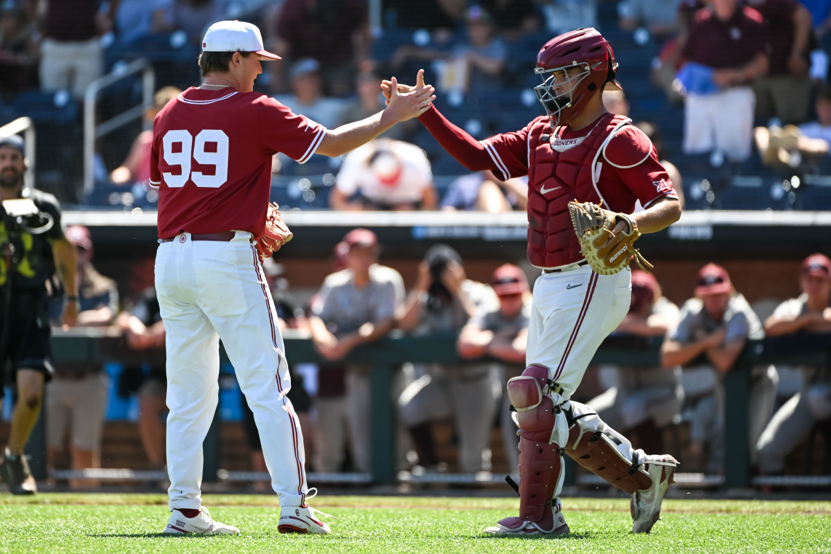 Jun 22, 2022; Omaha, NE, USA; Oklahoma Sooners pitcher Trevin Michael (99) greets catcher Jimmy Crooks (3) after the win against the Texas A&M Aggies at Charles Schwab Field.