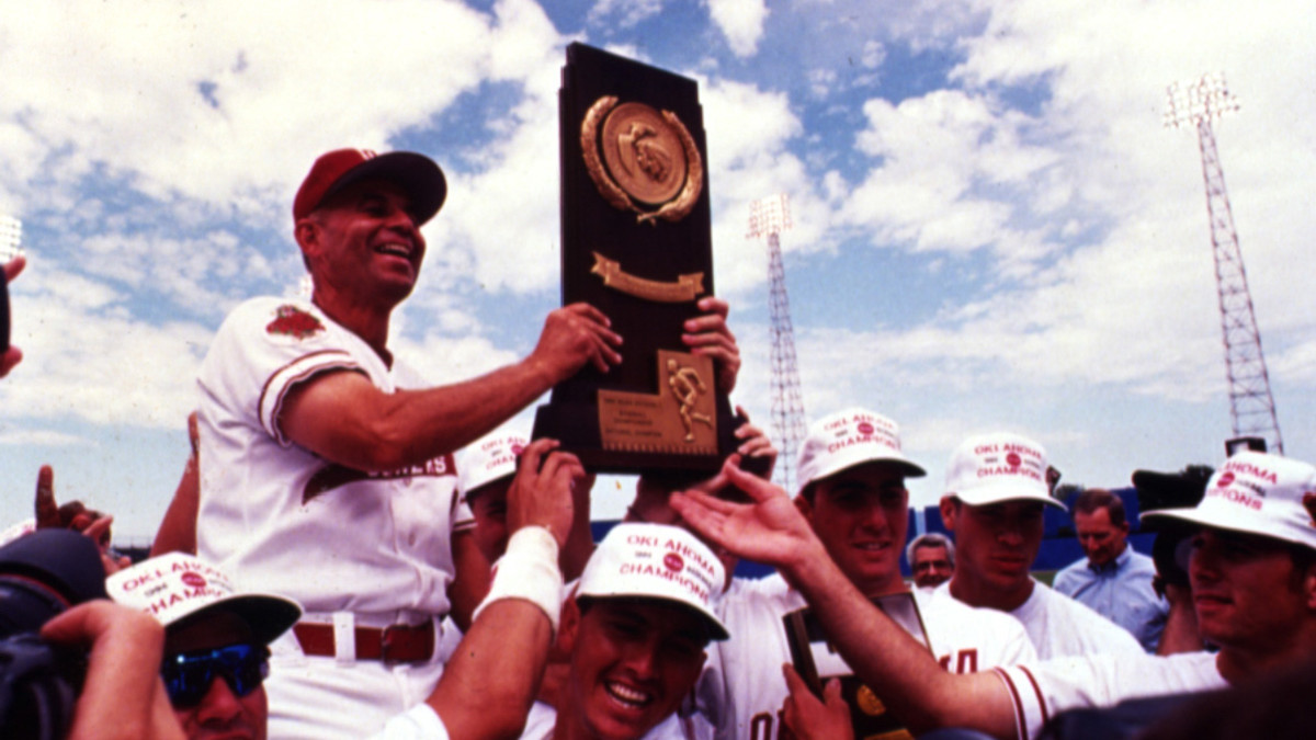 The Sooners hoist Larry Cochell and the trophy.