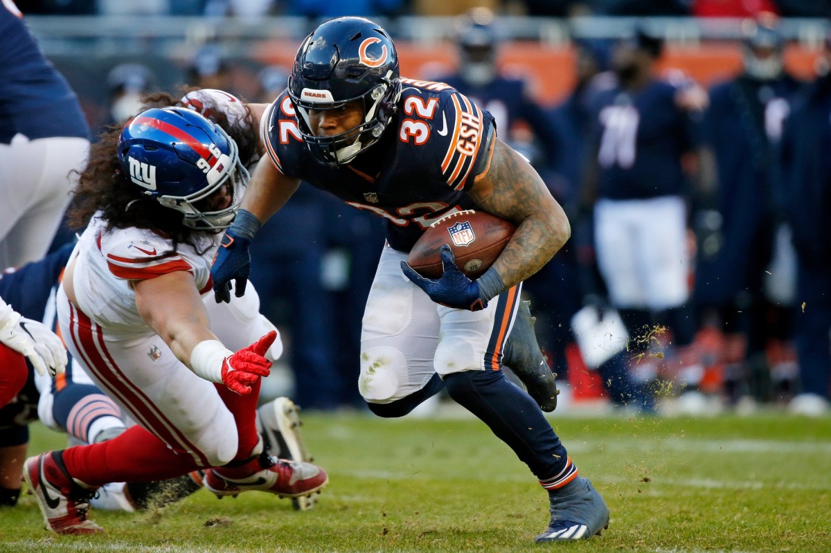 Jan 2, 2022; Chicago, Illinois, USA; Chicago Bears running back David Montgomery (32) runs with the ball as he evades the tackle of New York Giants defensive tackle David Moa (96) during the second half at Soldier Field.