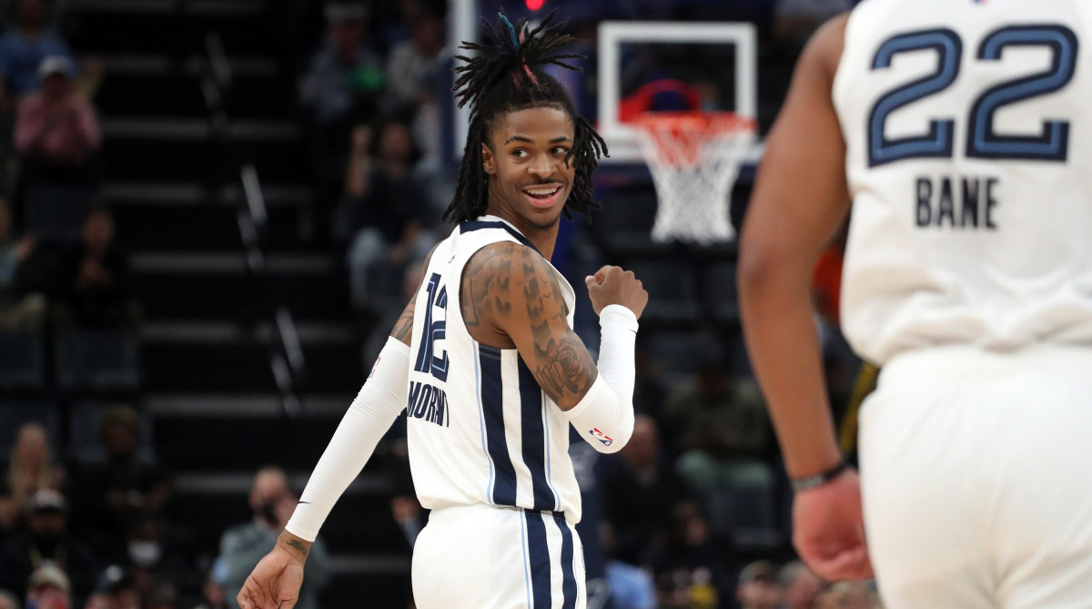 Grizzlies guard Ja Morant smiles at the Nuggets bench.