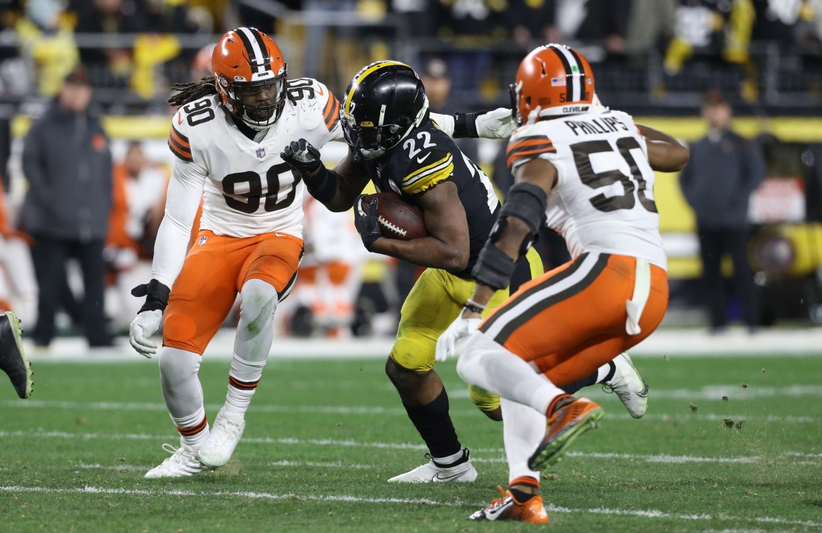 Jan 3, 2022; Pittsburgh, Pennsylvania, USA; Pittsburgh Steelers running back Najee Harris (22) runs the ball against Cleveland Browns defensive end Jadeveon Clowney (90) and linebacker Jacob Phillips (50) during the second quarter at Heinz Field. Mandatory Credit: Charles LeClaire-USA TODAY Sports