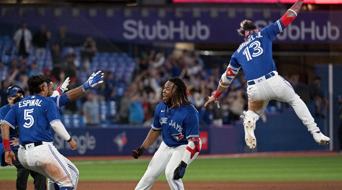 Jun 28, 2022; Toronto, Ontario, CAN; Toronto Blue Jays first baseman Vladimir Guerrero Jr. (27, right) is greeted by team mates after he hit a walkoff single RBI against the Boston Red Sox in the ninth inning at Rogers Centre.