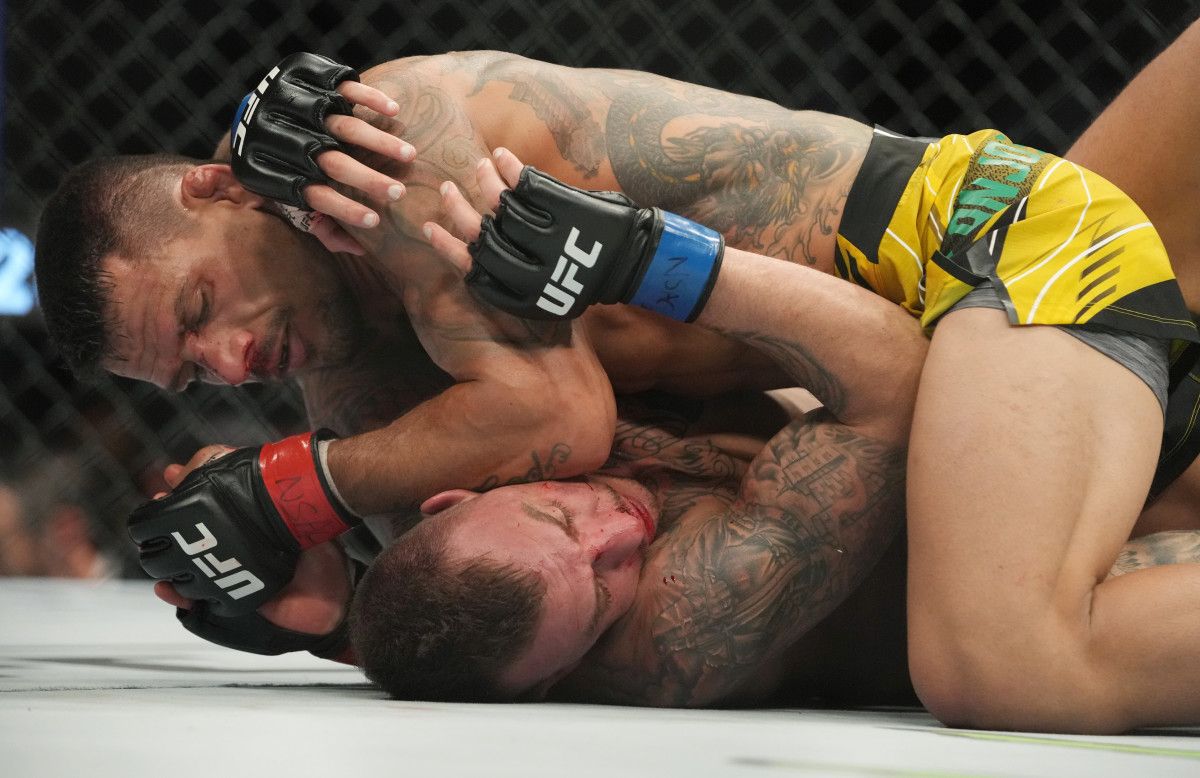 Rafael Dos Anjos (red gloves) fights Renato Moicano (blue gloves) during UFC 272 at T-Mobile Arena.