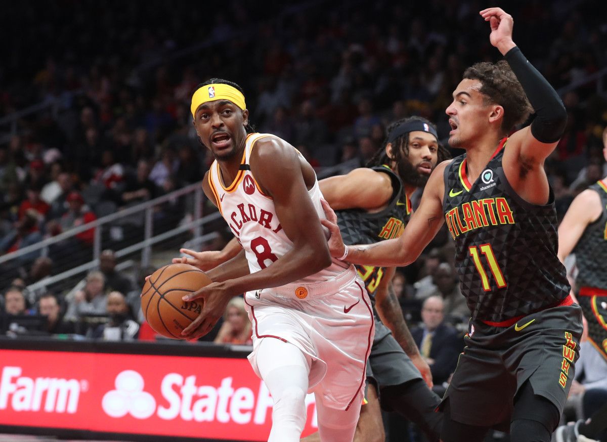 Indiana Pacers forward Justin Holiday (8) drives against Atlanta Hawks guard DeAndre' Bembry (95) and guard Trae Young (11) in the first half at State Farm Arena.