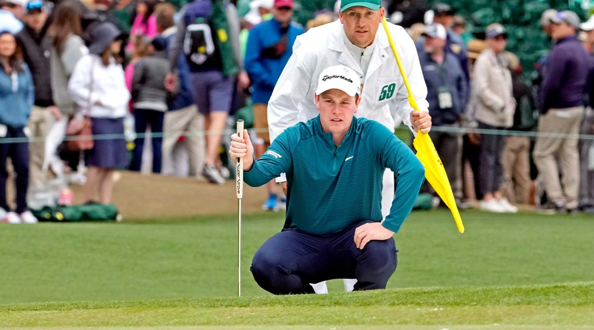 Apr 9, 2022; Augusta, Georgia, USA; Robert MacIntyre lines up his putt with his caddie Michael Thomson on the sixth green during the third round of The Masters golf tournament.