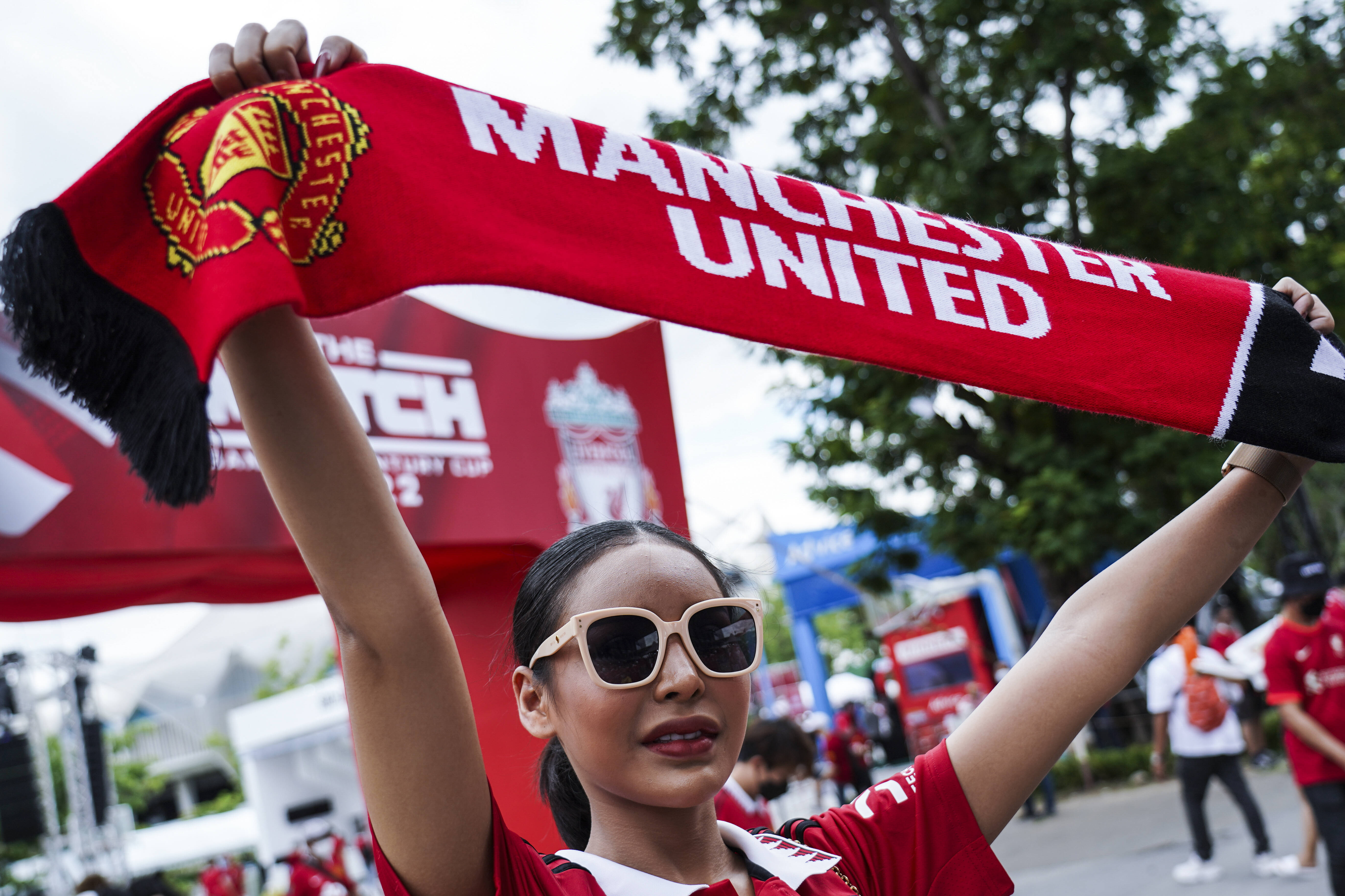 A Manchester United fan pictured proudly holding a club scarf ahead of her team's pre-season win over Liverpool in Bangkok in July 2022