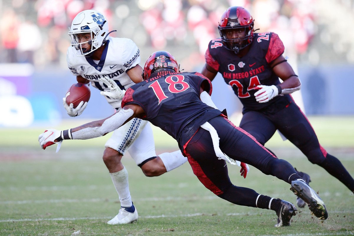 Dec 4, 2021; Carson, CA, USA; Utah State Aggies wide receiver Deven Thompkins (13) runs the ball against San Diego State Aztecs safety Trenton Thompson (18) and linebacker Segun Olubi (24) during the second half of the Mountain West Conference championship game at Dignity Health Sports Park.