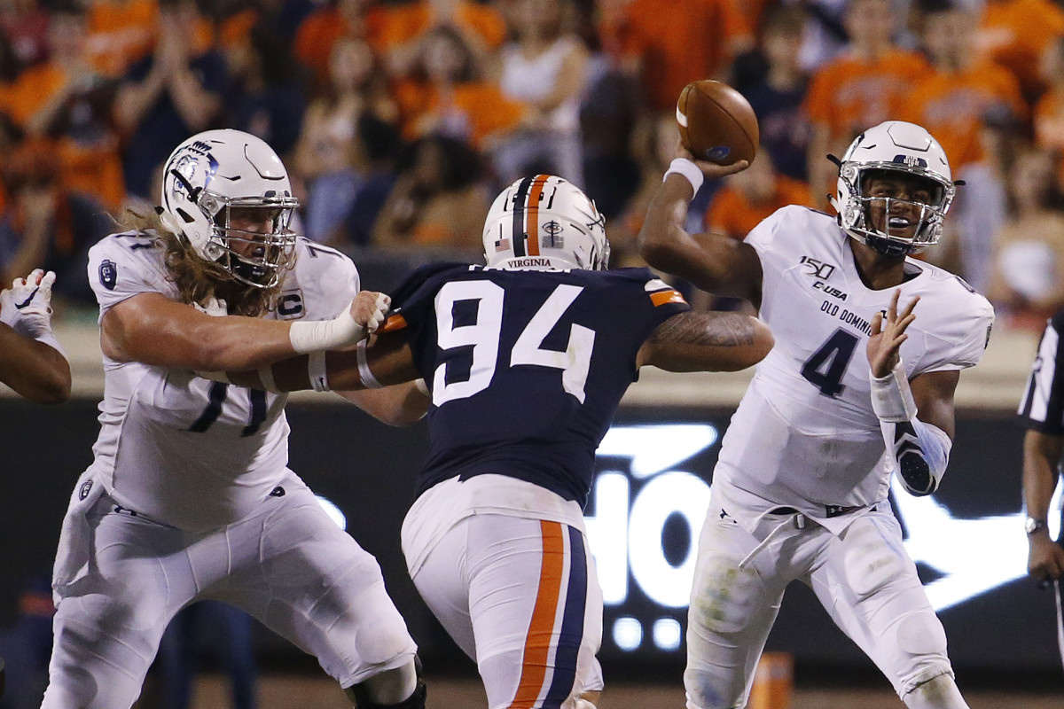 Old Dominion Monarchs quarterback Stone Smartt (4) passes the ball as Virginia Cavaliers defensive tackle Aaron Faumui (94) defends in the second quarter at Scott Stadium.