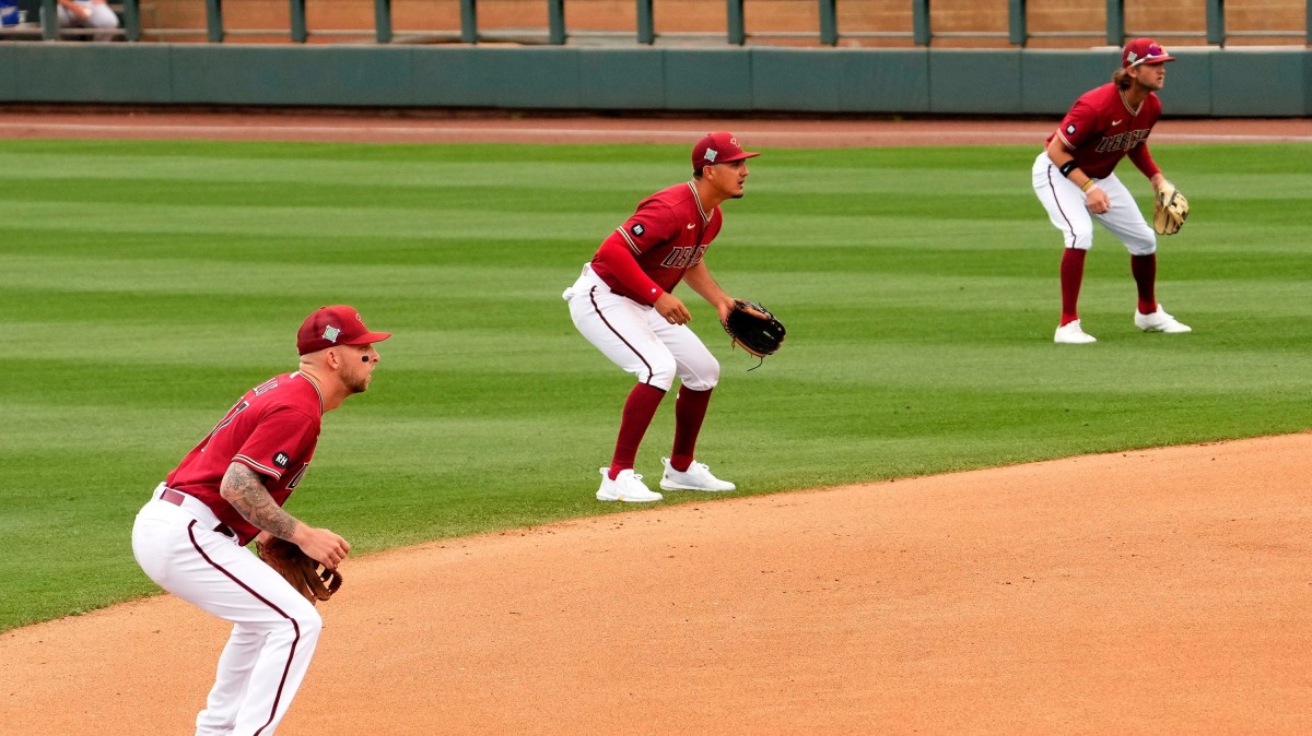 Three baseball defenders line up in a shift