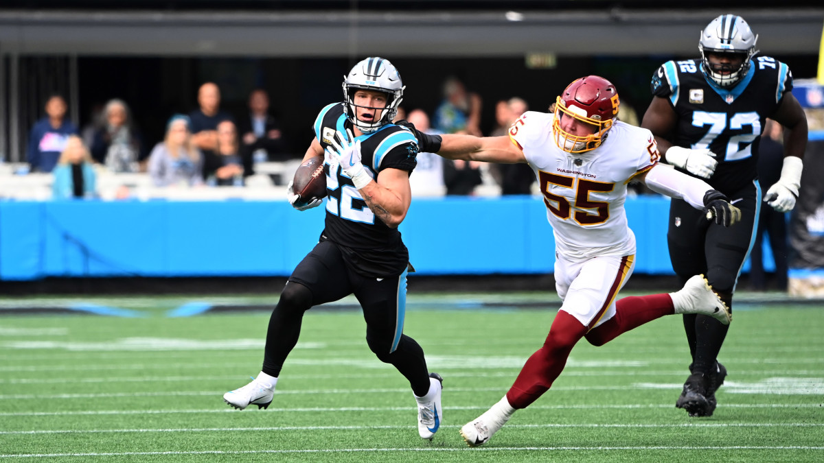 Carolina Panthers running back Christian McCaffrey (22) with the ball as Washington Football Team outside linebacker Cole Holcomb (55) defends in the first quarter at Bank of America Stadium.
