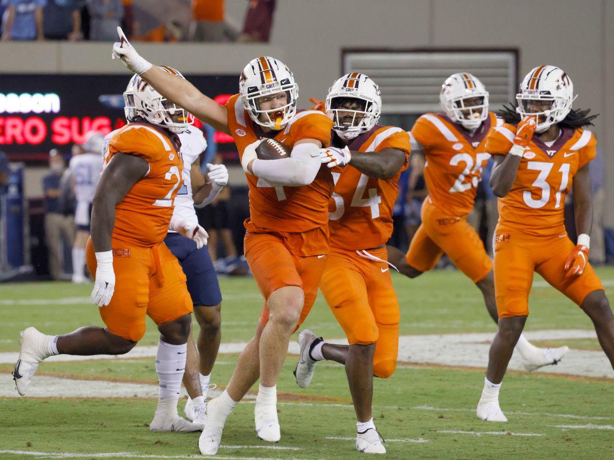 Virginia Tech Hokies linebacker Dax Hollifield (4) celebrates after he intercepts a pass with teammates linebacker Alan Tisdale (34) and defensive back Nasir Peoples (31) during the second half against the North Carolina Tar Heels against the North Carolina Tar Heels at Lane Stadium.