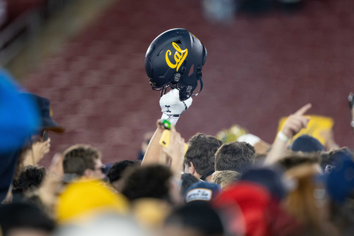 California Golden Bears helmet is raised into the air amongst fans after defeating the Stanford Cardinal at Stanford Stadium.