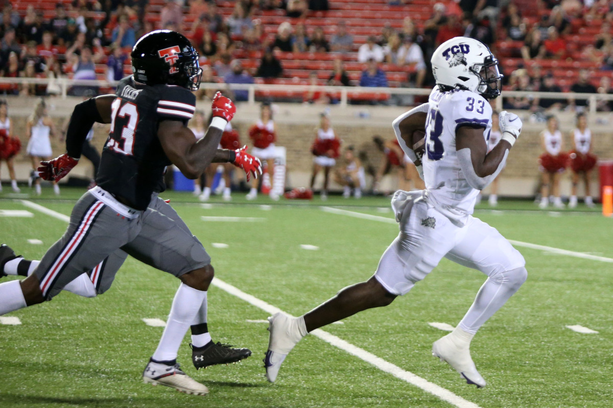 Oct 9, 2021; Lubbock, Texas, USA; Texas Christian Horned Frogs running back Kendre Miller (33) rushes for a touchdown against Texas Tech Red Raiders defensive corner back DaMarcus Fields (23) in the second half at Jones AT&T Stadium.