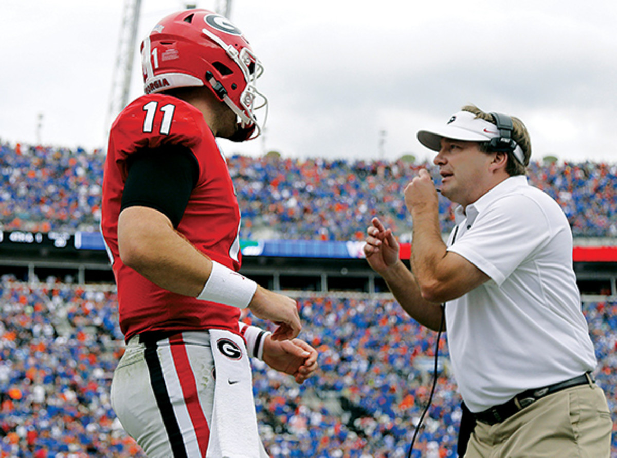 Georgia Bulldogs quarterback Jake Fromm (11) talks with head coach Kirby Smart during the first half against the Florida Gators at TIAA Bank Field.