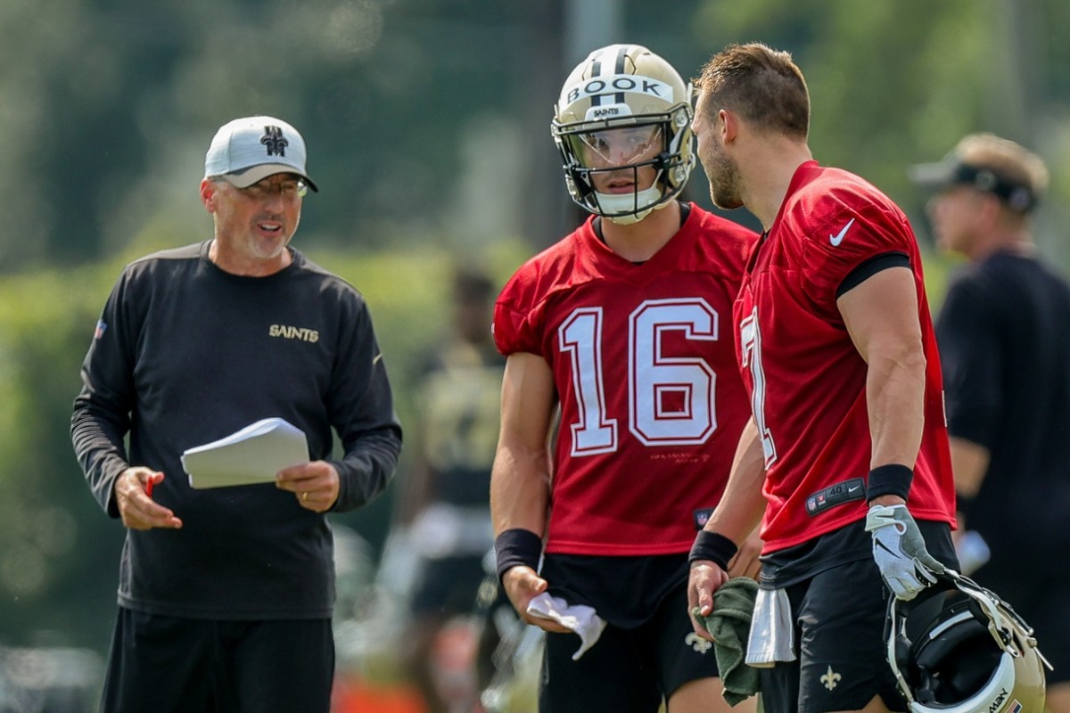 Jul 31, 2021; Taysom Hill (7) talks with quarterback Ian Book (16) and offensive coordinator Pete Carmichael during practice at the Saints Training Facility. Mandatory Credit: Stephen Lew-USA TODAY Sports