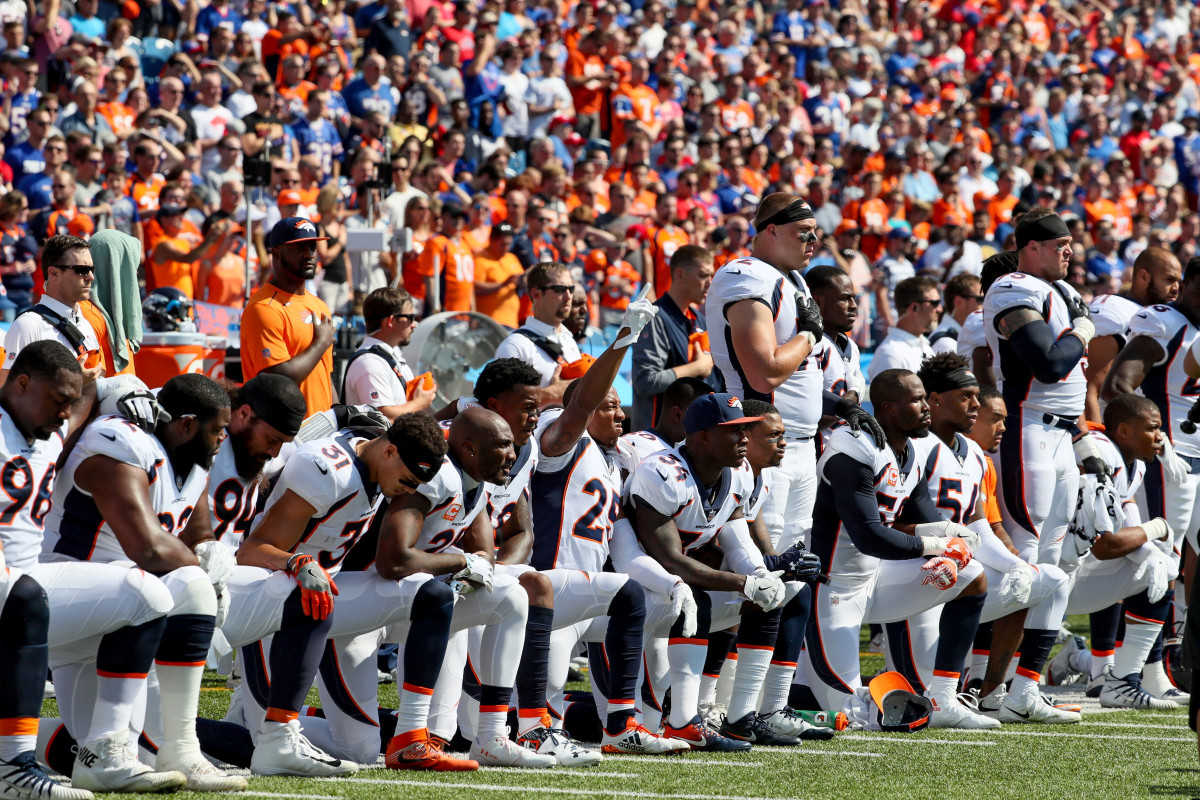 Denver Broncos come together to protest during the national anthem.