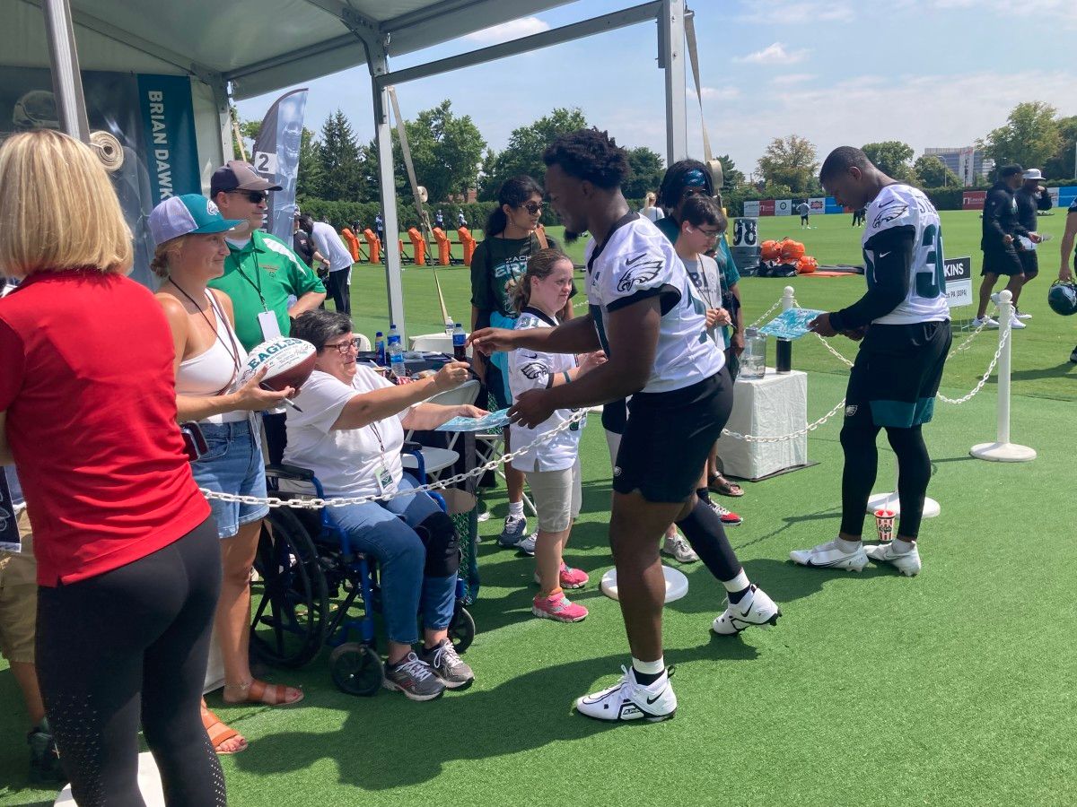 Nakobe Dean (left) and JaCoby Stevens sign autographs following the first day of Eagles training camp