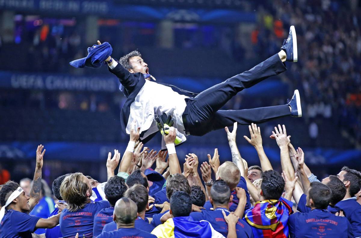 Luis Enrique pictured being thrown in the air by his Barcelona players after winning the Champions League in 2015