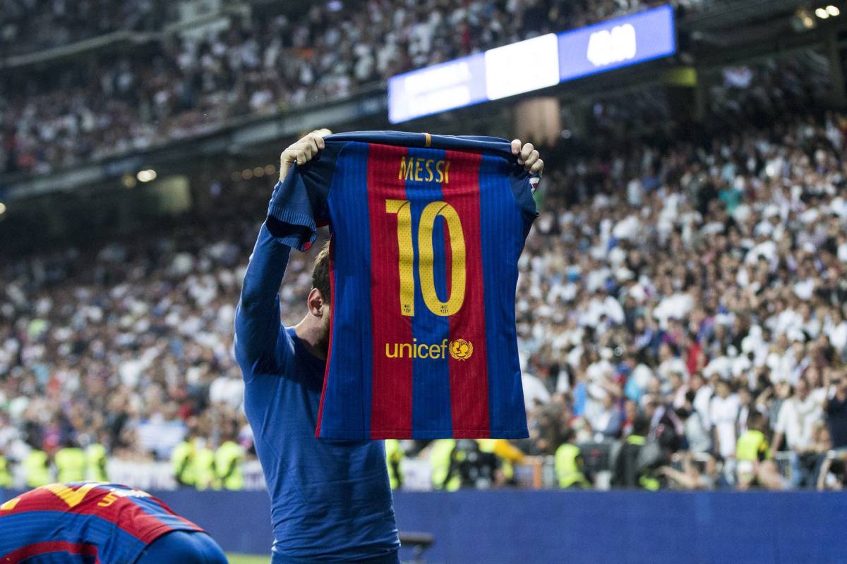 Lionel Messi holds up his Barcelona shirt in front of Real Madrid fans after scoring at the Bernabeu in 2017