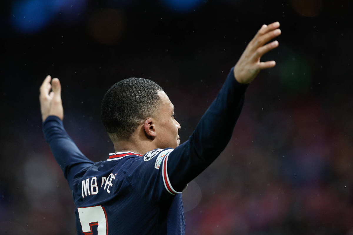 Kylian Mbappe celebrates with his arms raised after scoring for PSG against Real Madrid in February 2022