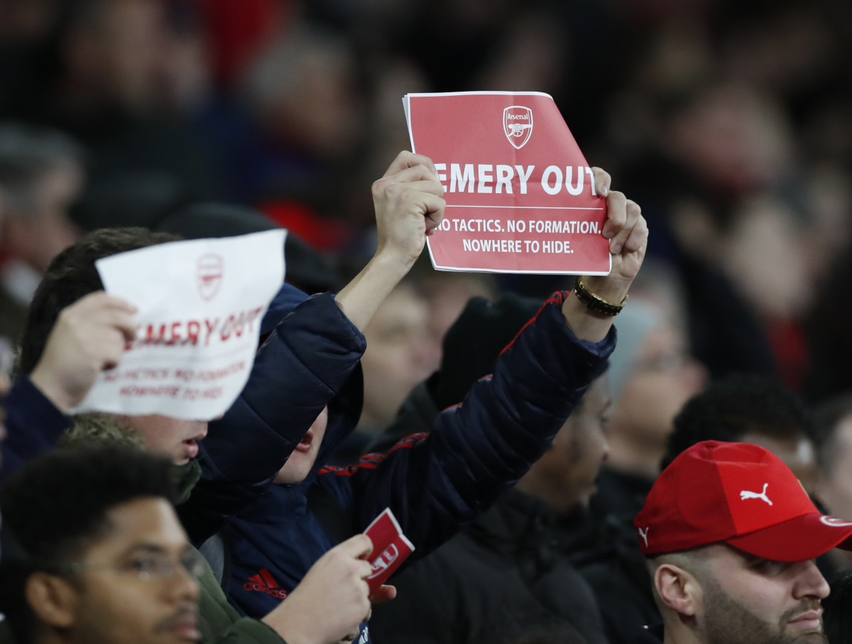 Arsenal fans pictured holding up "EMERY OUT" posters at Unai Emery's final game as the club's manager in November 2019