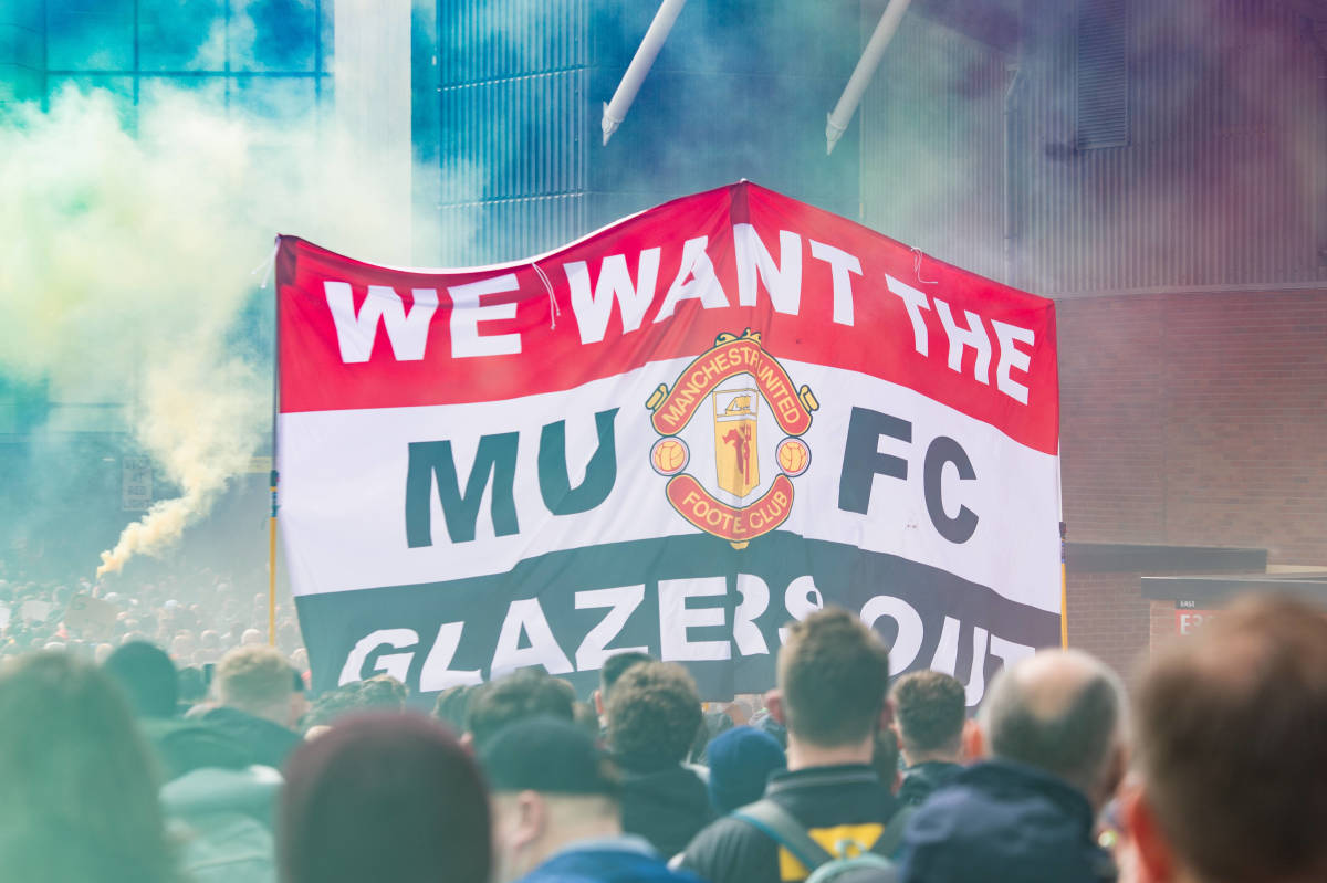 A banner reading "WE WANT THE GLAZERS OUT" is pictured during a protest by Manchester United fans in 2021