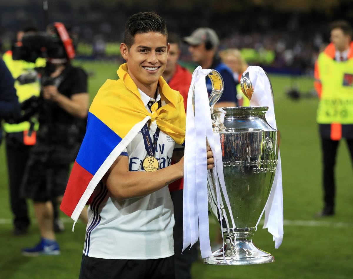 James Rodriguez pictured wearing the Colombian flag around his shoulders while lifting the Champions League trophy as a Real Madrid player in 2017