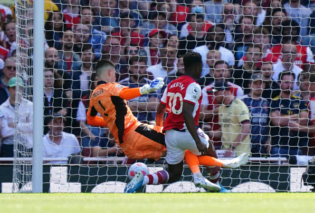 Eddie Nketiah pictured scoring for Arsenal after tackling Leeds goalkeeper Illan Meslier in a Premier League game in May 2022