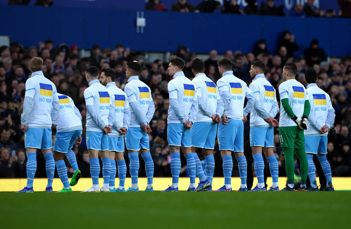 Manchester City players wear tee-shirts with the Ukraine flag and the words "NO WAR"