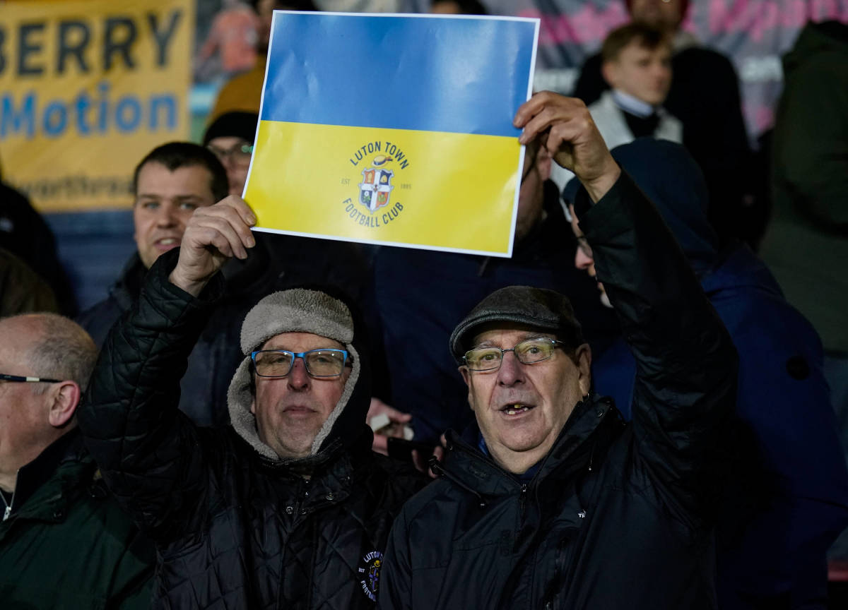 Two Luton Town fans hold up a Ukrainian flag during their team's FA Cup game with Chelsea
