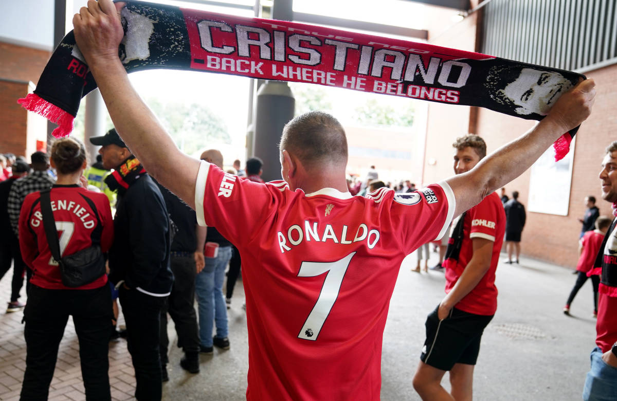 A Manchester United fan is pictured with Cristiano Ronaldo's name on his shirt and scarf at Old Trafford in September 2021