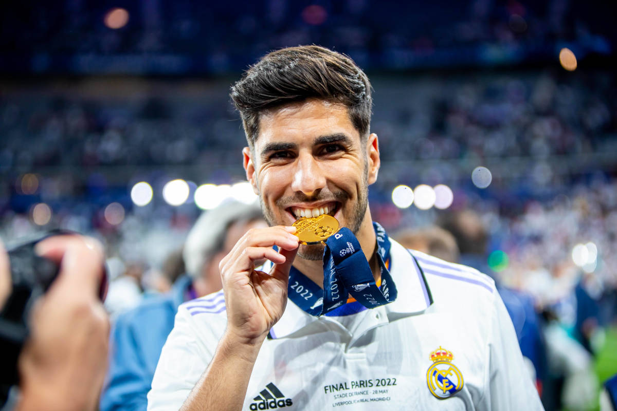 Marco Asensio pictured biting his third Champions League winner's medal after Real Madrid's victory over Liverpool in the 2022 final