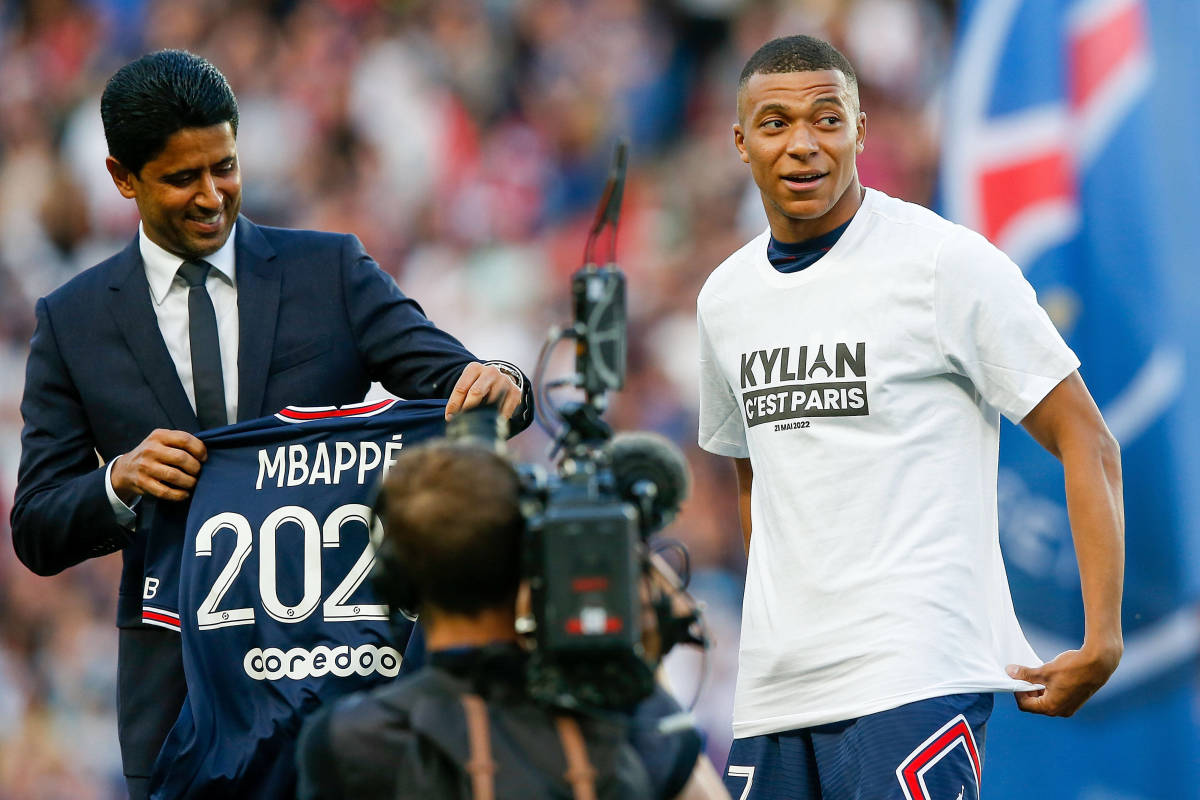 PSG president Nasser Al Khelaifi pictured (left) holding up a shirt printed with "Mbappe 2025" after Kylian Mbappe (right) signed a new contract