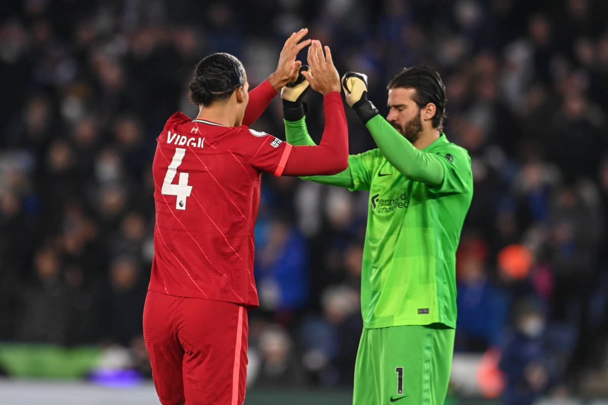 Virgil van Dijk (left) pictured exchanging high fives with Alisson Becker during Liverpool's game at Leicester in December 2021