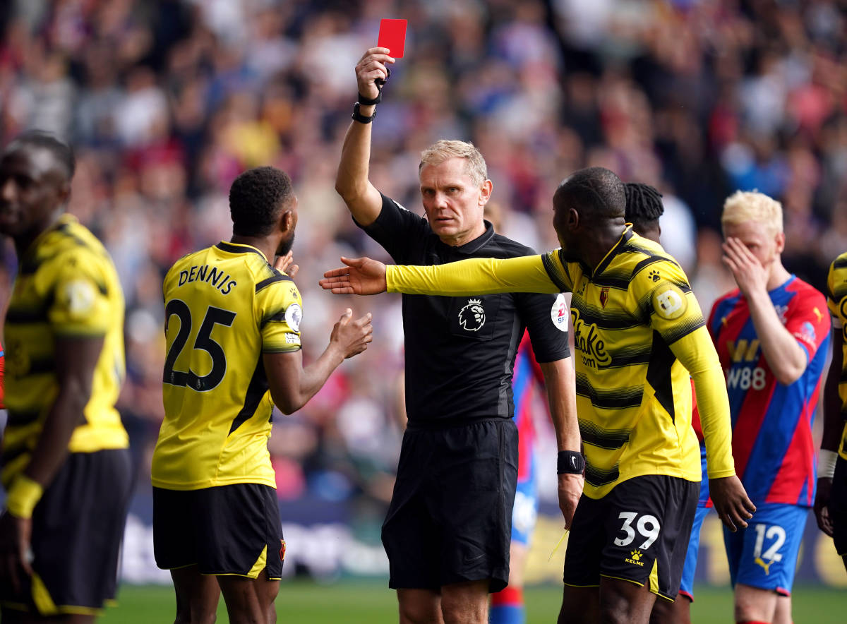 Referee Graham Scott pictured showing a red card to Hassane Kamara (far left) during Watford's 1-0 loss at Crystal Palace, which confirmed their relegation from the Premier League in May 2022