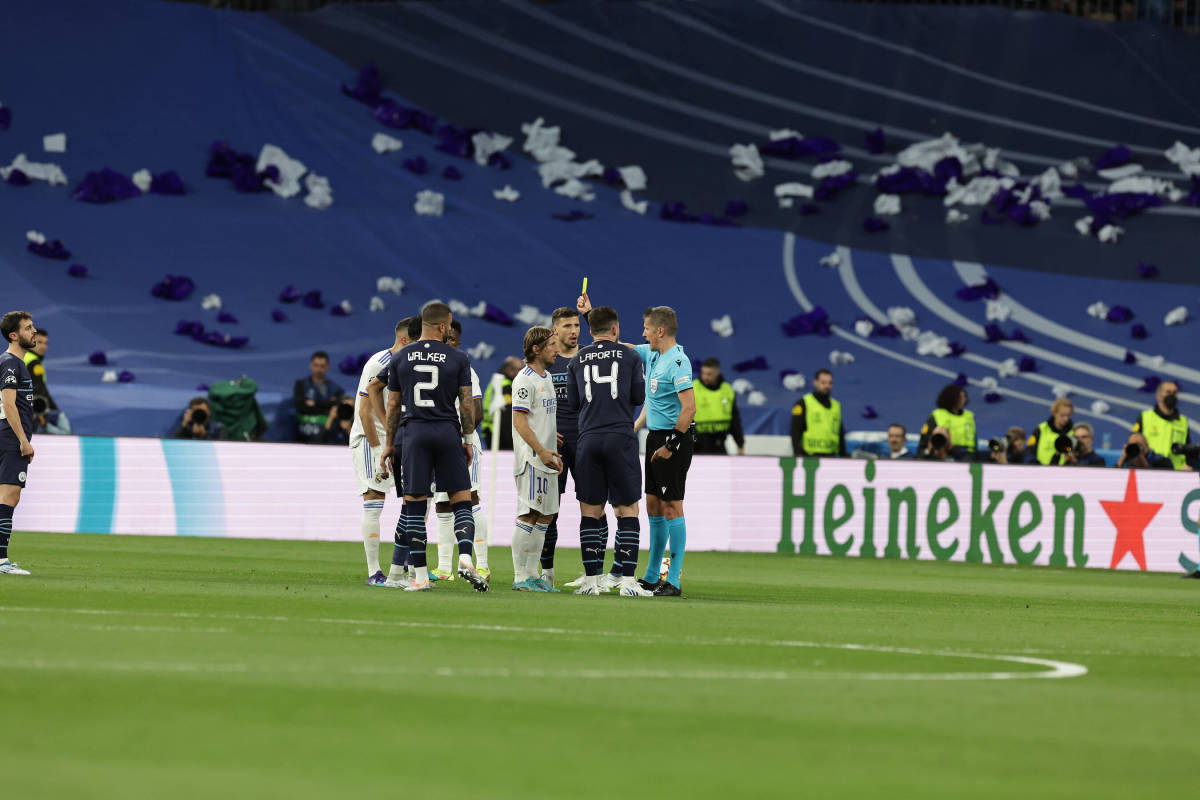 Referee Daniele Orsato pictured issuing a yellow card to Luka Modric after the Real Madrid midfielder was involved in a spat with Man City defender Aymeric Laporte
