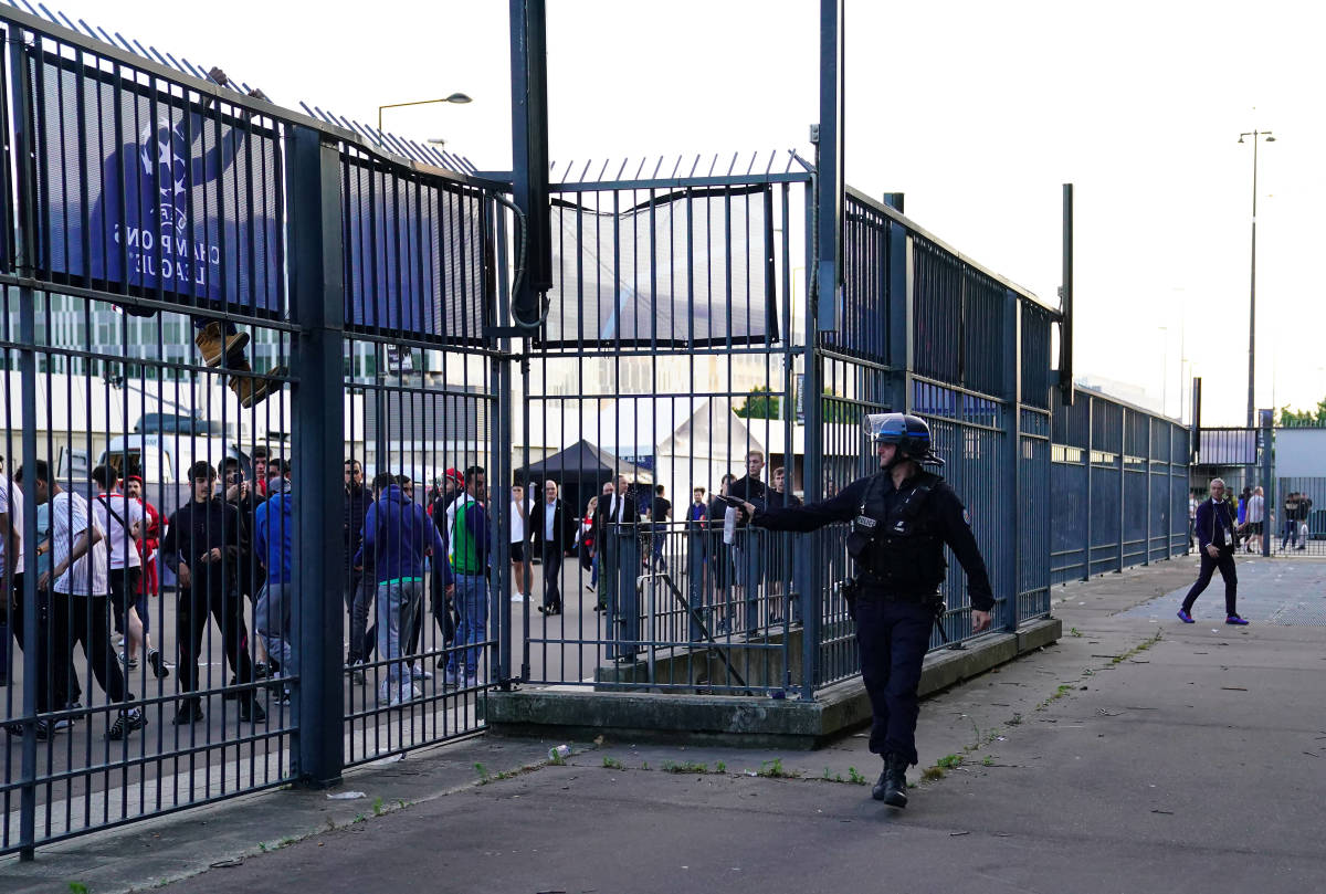 A Paris police officer is pictured spraying tear gas towards a group of Liverpool fans outside the Stade de France