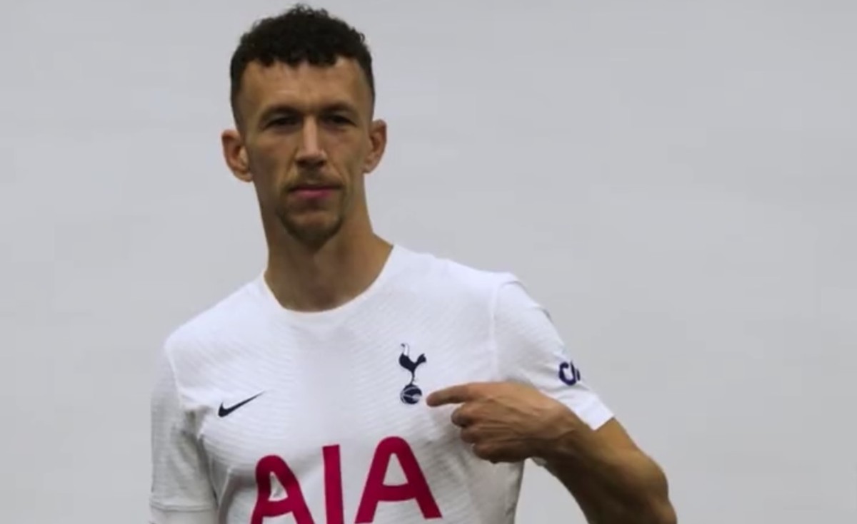 Ivan Perisic points to the badge on his Tottenham jersey after signing from Inter Milan