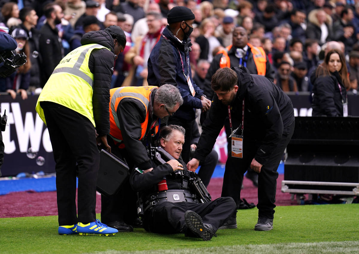 A steady cam operator is helped up after falling over while filming Aaron Cresswell's goal celebration for West Ham vs Everton