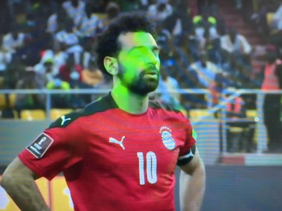 Mo Salah's face is filled with green lasers before he takes a penalty for Egypt vs Senegal in a World Cup playoff penalty shootout against Senegal