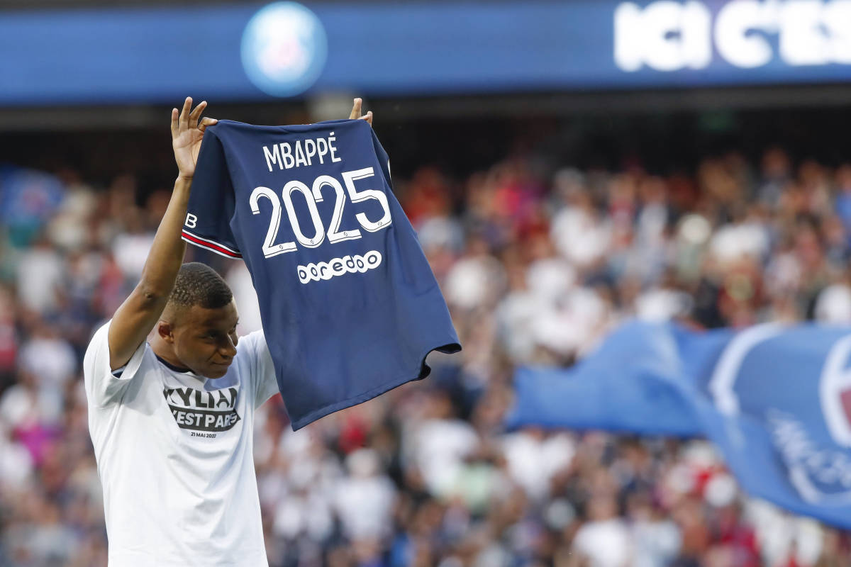 Kylian Mbappe pictured holding up a jersey reading "Mbappe 2025" after signing his new PSG contract in May 2022