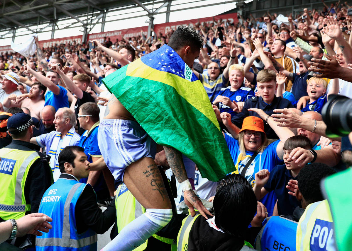 Raphinha pictured climbing into a stand full of Leeds fans following his side's 2-1 win at Brentford in May 2022