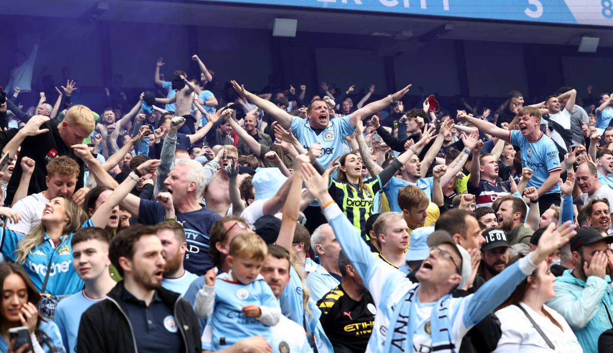 Manchester City fans pictured celebrating during their side's 3-2 win over Aston Villa in May 2022 which sealed the Premier League title on the final day of the season