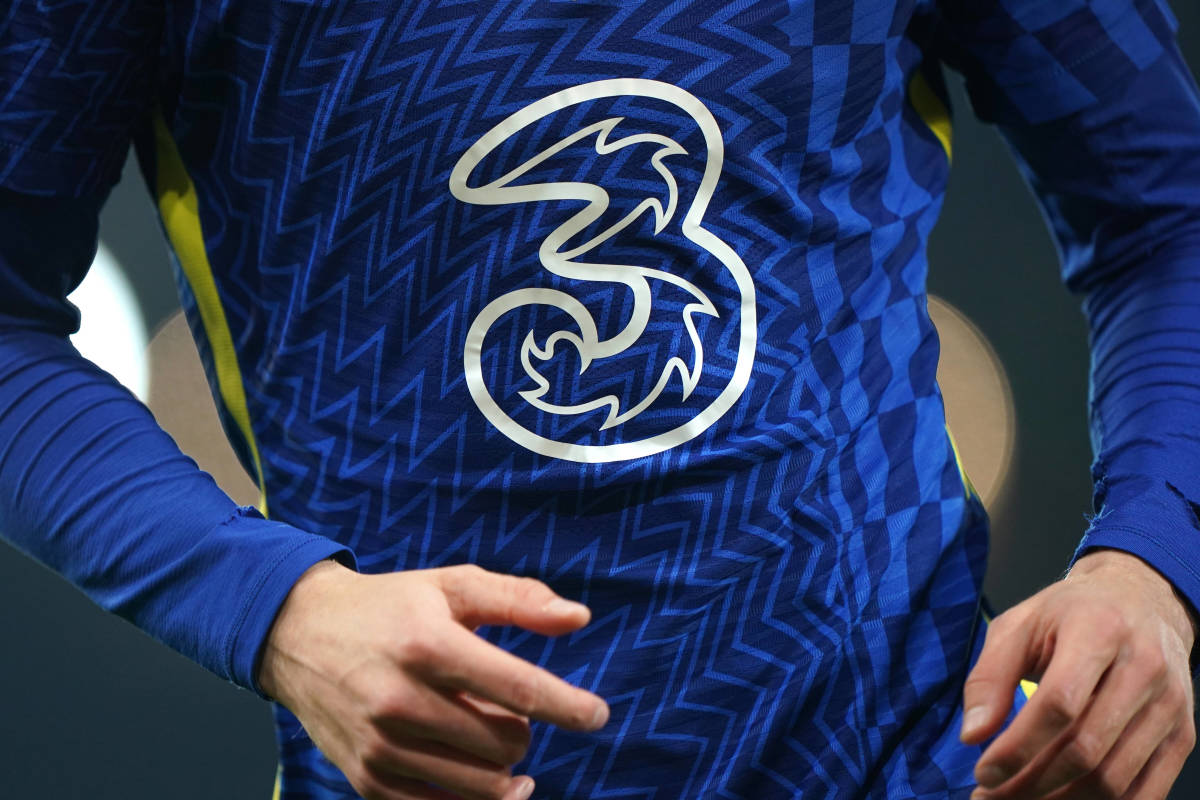A close-up look at the front of a Chelsea shirt featuring the logo of Three