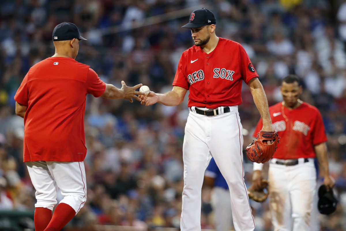 Boston Red Sox’s Nathan Eovaldi, center, hands the ball to manager Alex Cora as he is removed during the third inning of the team’s baseball game against the Toronto Blue Jays, Friday, July 22, 2022, in Boston.