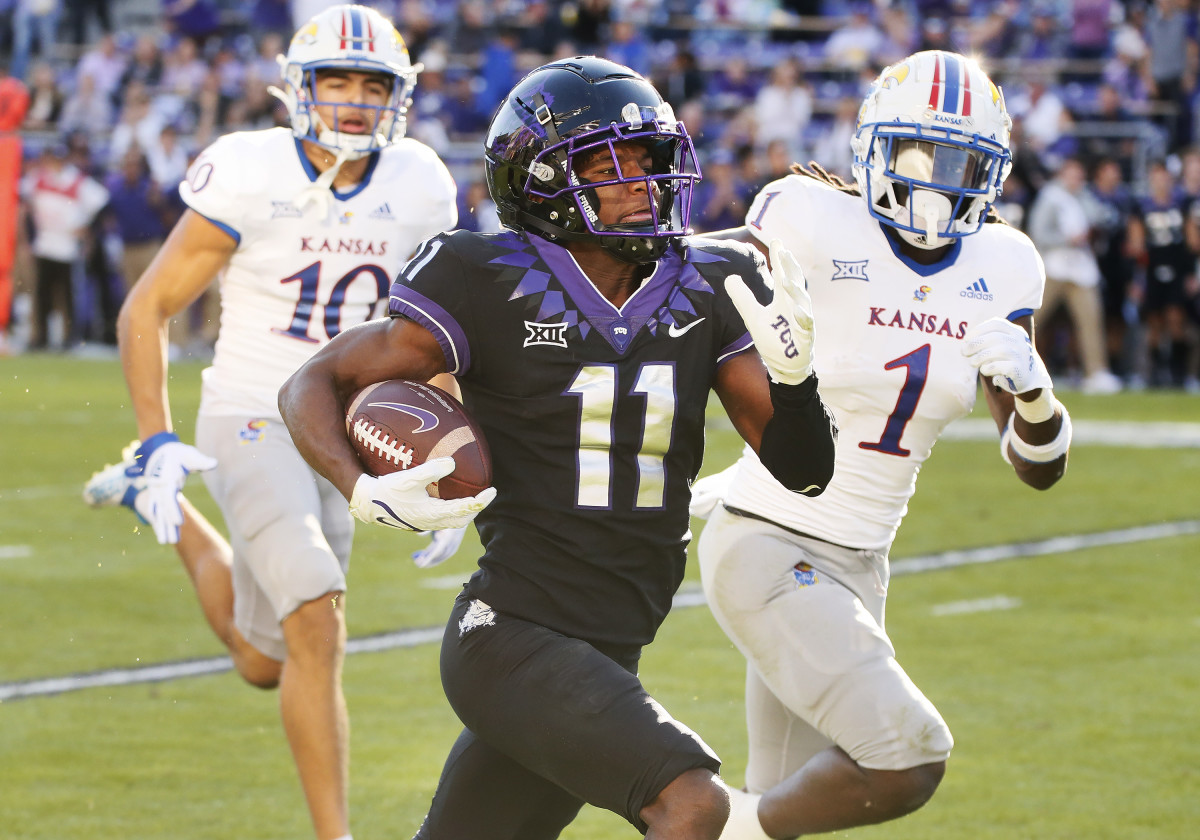 Nov 20, 2021; Fort Worth, Texas, USA; TCU Horned Frogs wide receiver Derius Davis carries the ball a 43-yard touchdown as he runs by Kansas Jayhawks safety Kenny Logan Jr. (1) during the first half at Amon G. Carter Stadium.