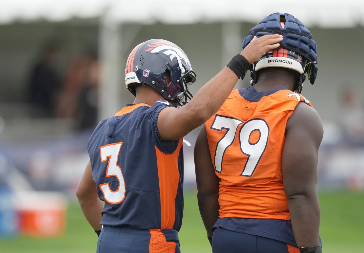 Denver Broncos quarterback Russell Wilson and center Lloyd Cushenberry (79) during training camp at the UCHealth Training Center.